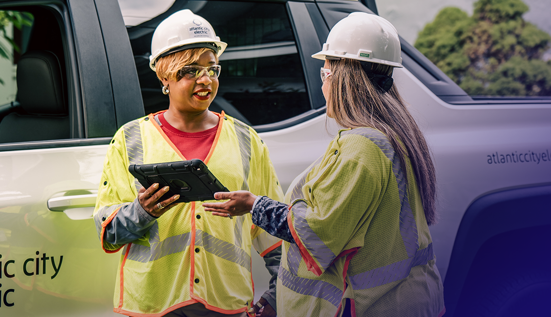 Two employees demonstrating to a customer on an ipad