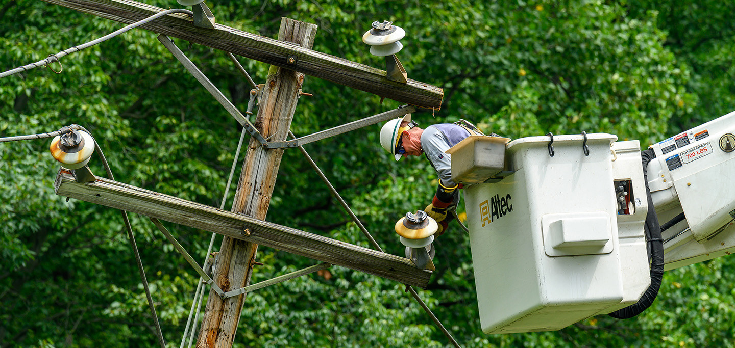 Lineworker fixing utility pole in a bucket truck