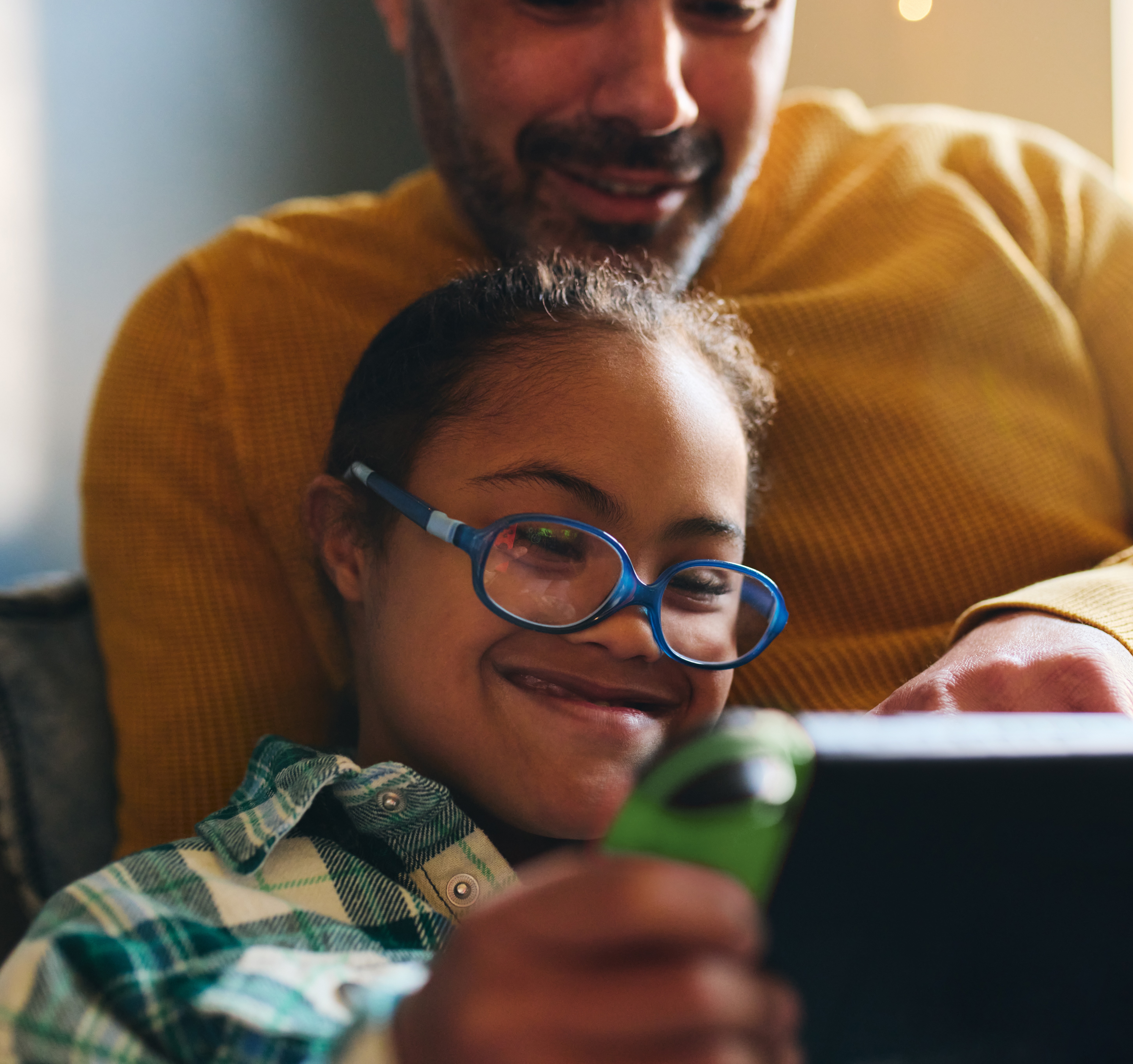 child playing game console with father