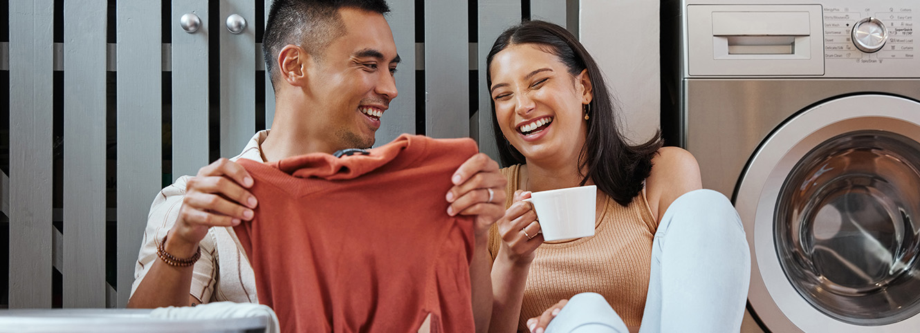 Couple doing laundy and drinking coffee