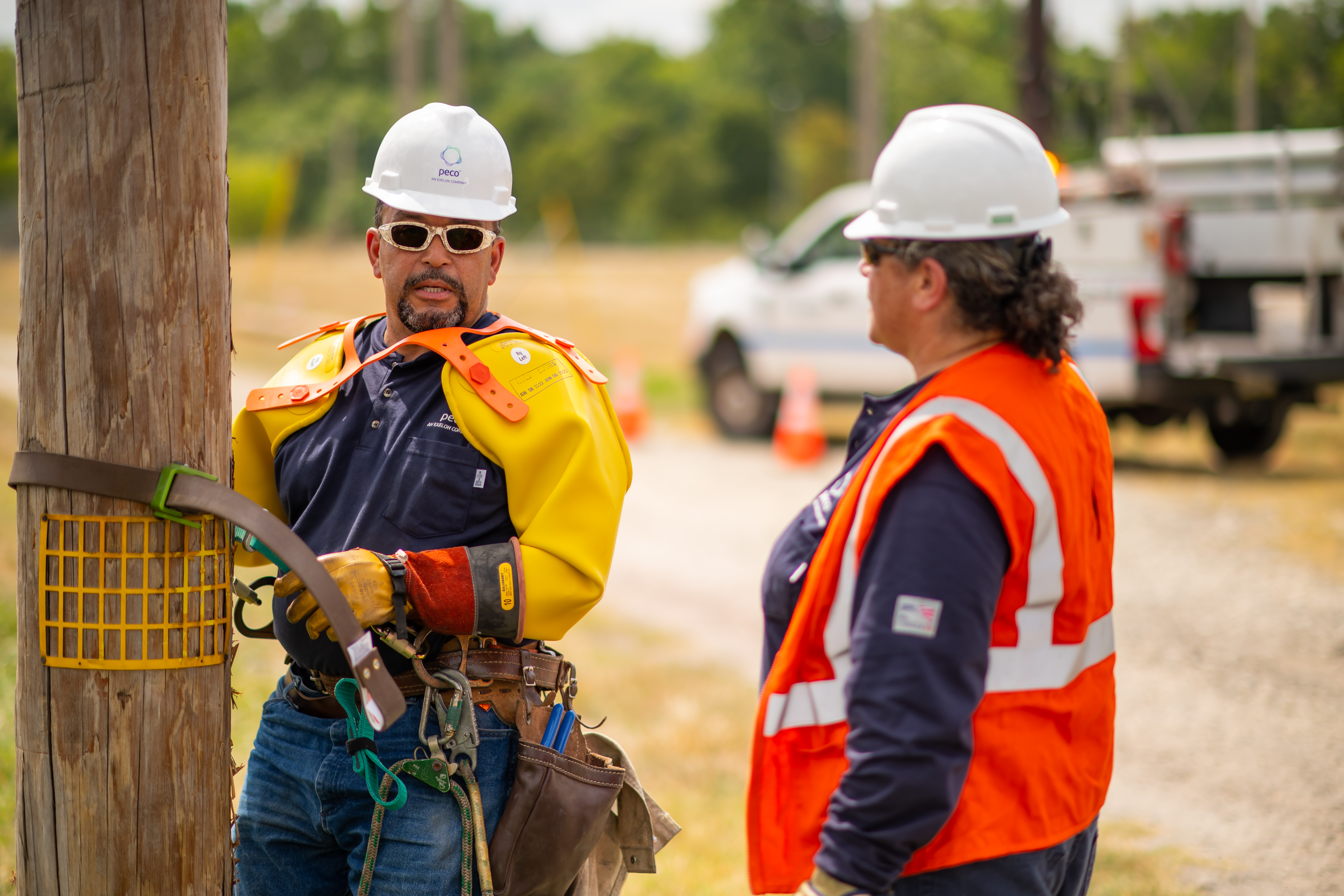 lineworkers checking safety before climbing utility pole