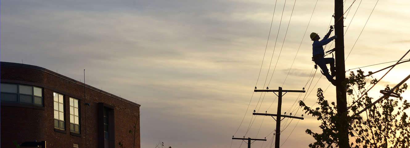Lineworker climbing a utility pole
