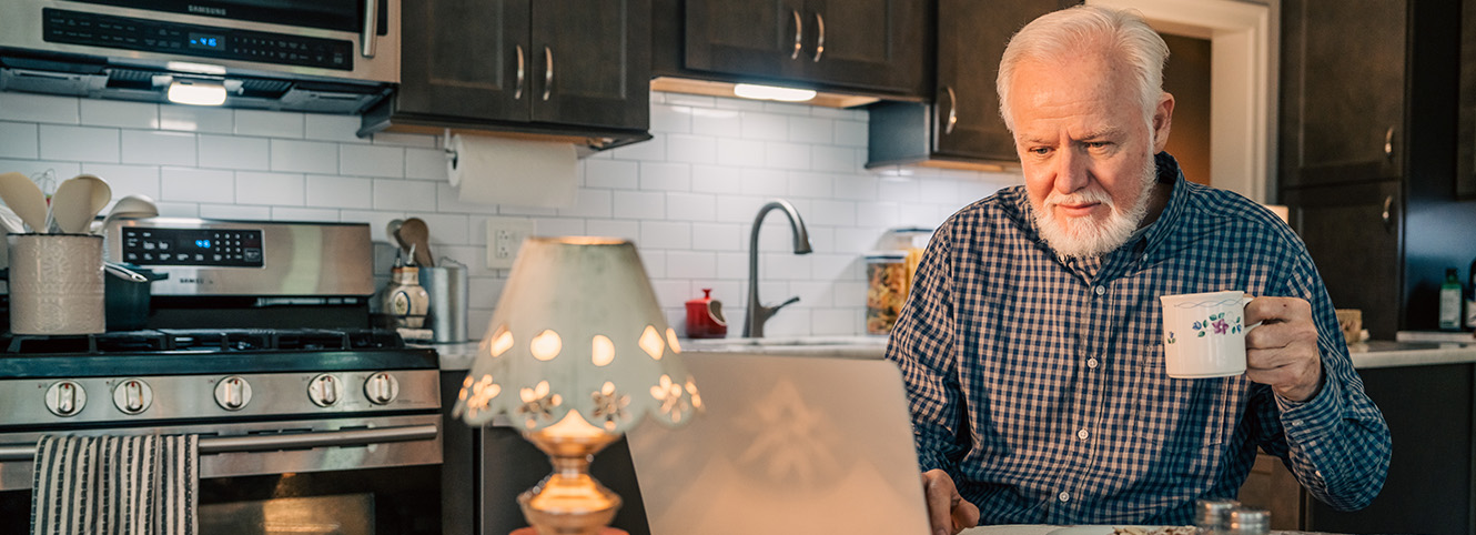 Man working on computer in the kitchen