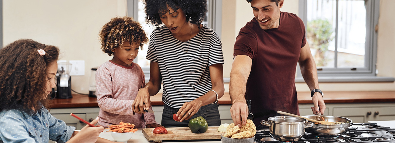 Family cooking together using a gas stove